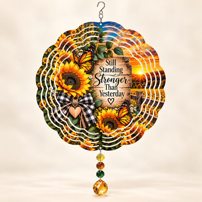 Illustrative front mockup of Still Standing sunflower butterfly 8-inch wind spinner with example amber yellow green prisms